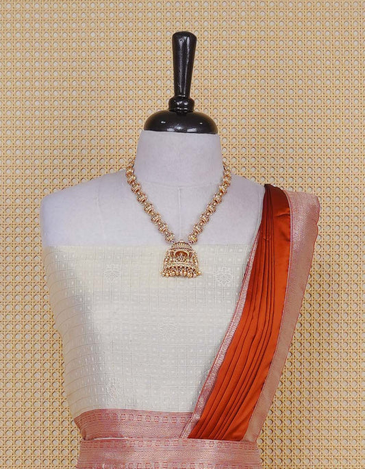 Cream colour Semi Silk Semi stitched dhavani set featuring Gold zari check pattern with motifs on body,contrast Peach colour with gold zari bordered skirt, paired with matching blouse piece & dupatta