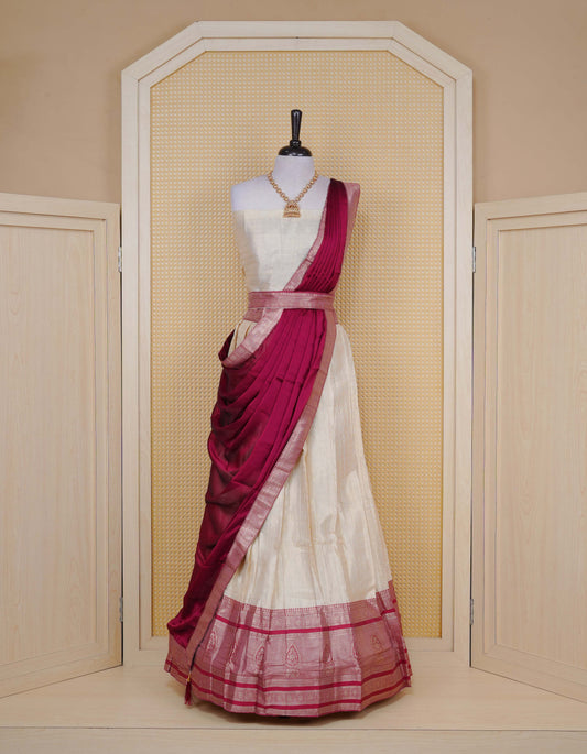Cream colour Semi Silk Semi stitched dhavani set featuring Gold zari check pattern with motifs on body ,contrast Red colour with gold zari bordered skirt, paired with matching blouse piece & dupatta.