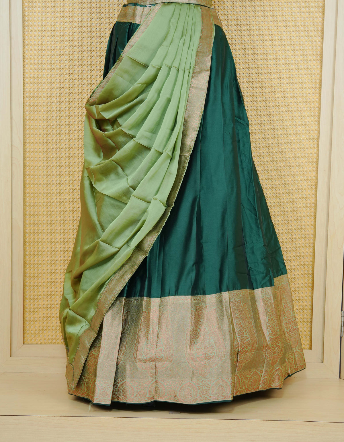 Bottle green colour Semi Silk  Semi stitched dhavani set featuring a Plain body with a matching contrast Pista Green colour with copper zari bordered skirt & blouse piece and dupatta.