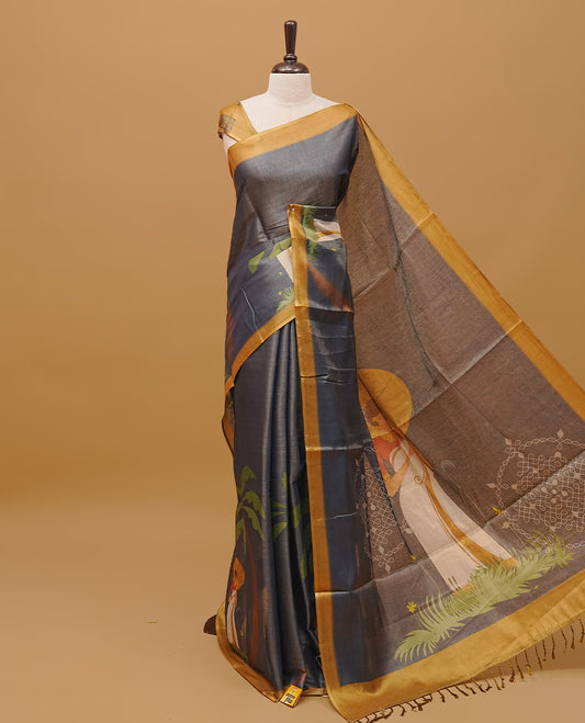 Grayish blue colour semi tissue saree featuring a Lady prints on the body, with gold colour border & pallu finished with tassels. Paired with a matching blouse piece.