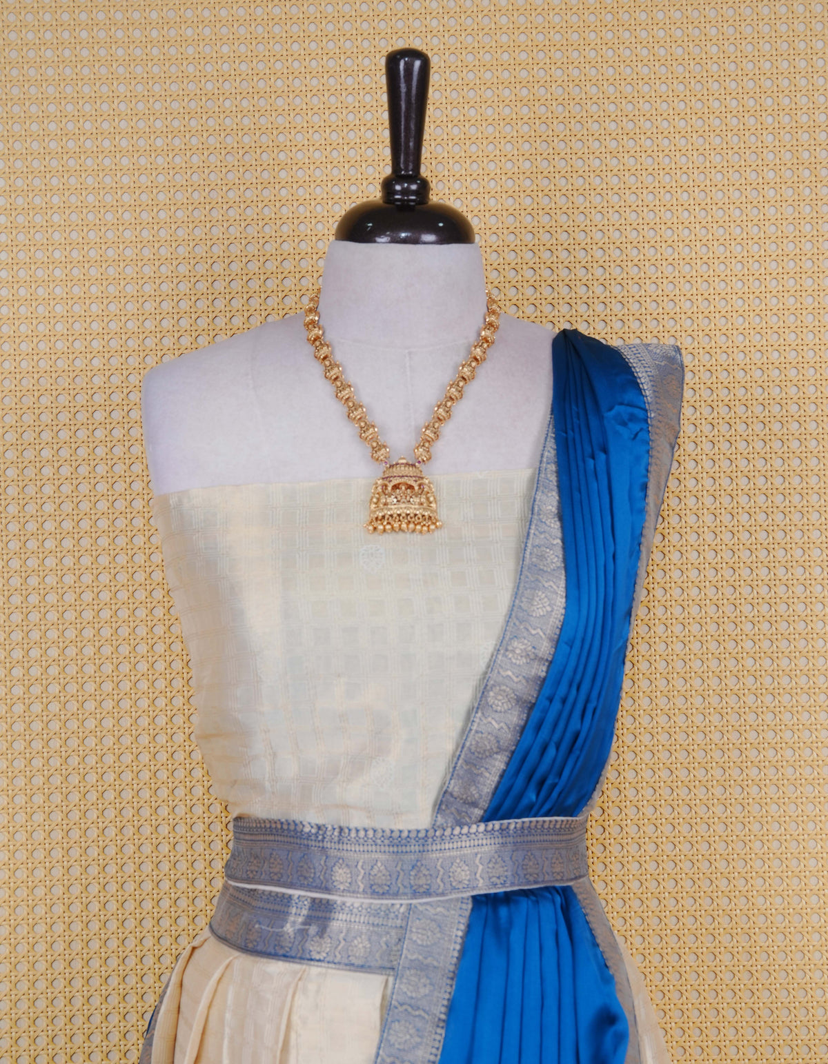 Cream colour tissue semi stitched dhavani set featuring gold zari Check patterns with motifs on the body and a matching Contrast Blue colour with  gold zari bordered skirt & blouse piece and dupatta.