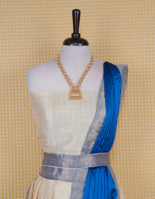 Cream colour tissue semi stitched dhavani set featuring gold zari Check patterns with motifs on the body and a matching Contrast Blue colour with  gold zari bordered skirt & blouse piece and dupatta.