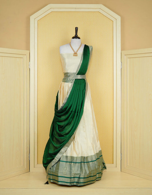 Cream colour tissue semi stitched dhavani set featuring gold zari Check patterns with motifs on the body and a matching Contrast Green colour with  gold zari bordered skirt & blouse piece and dupatta.