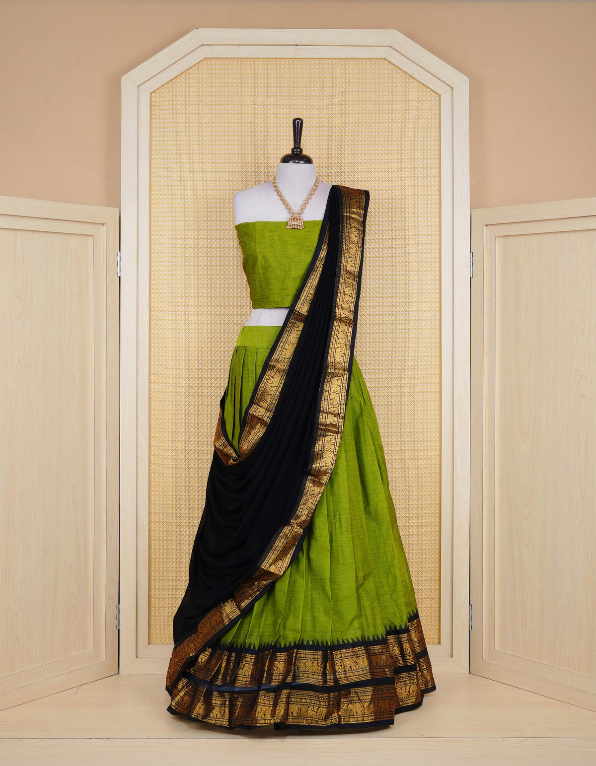 Green colour Chettinad Semi Stitched dhavani set Featuring contrast Black with Gold zari border on skirt, Contrast Blouse piece & matching dupatta.