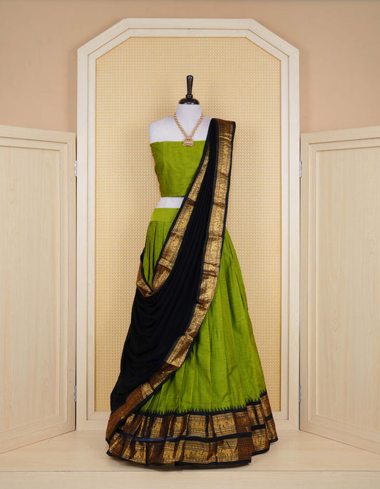 Green colour Chettinad Semi Stitched dhavani set Featuring contrast Black with Gold zari border on skirt, Contrast Blouse piece & matching dupatta.