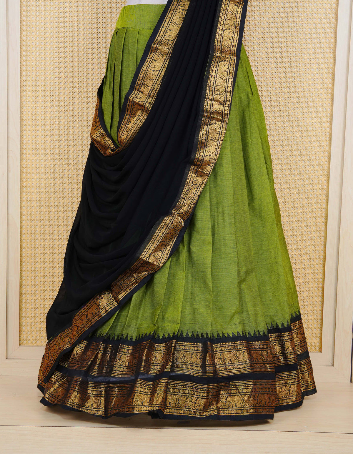 Green colour Chettinad Semi Stitched dhavani set Featuring contrast Black with Gold zari border on skirt, Contrast Blouse piece & matching dupatta.