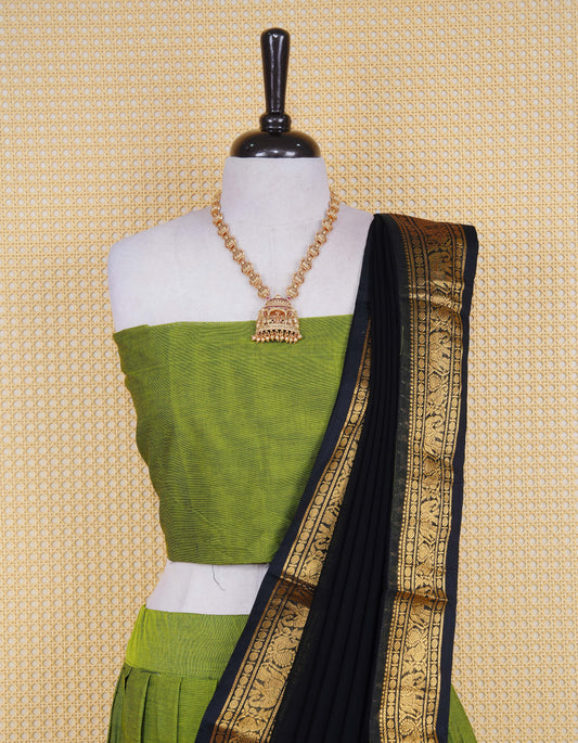 Green colour Chettinad Semi Stitched dhavani set Featuring contrast Black with Gold zari border on skirt, Contrast Blouse piece & matching dupatta.