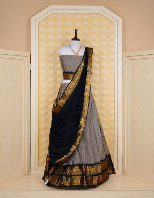 Grey colour Chettinad Semi Stitched dhavani set Featuring contrast Black with Gold zari border on skirt, Contrast Blouse piece & matching dupatta.