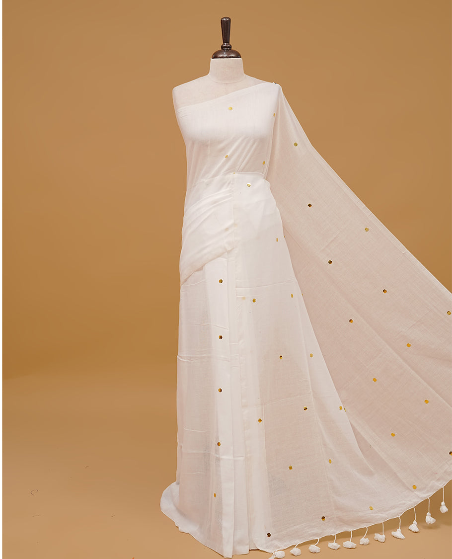 White colour mul cotton saree featuring sequin work on body & pallu finished with tassels. Paired with a matching blouse piece.