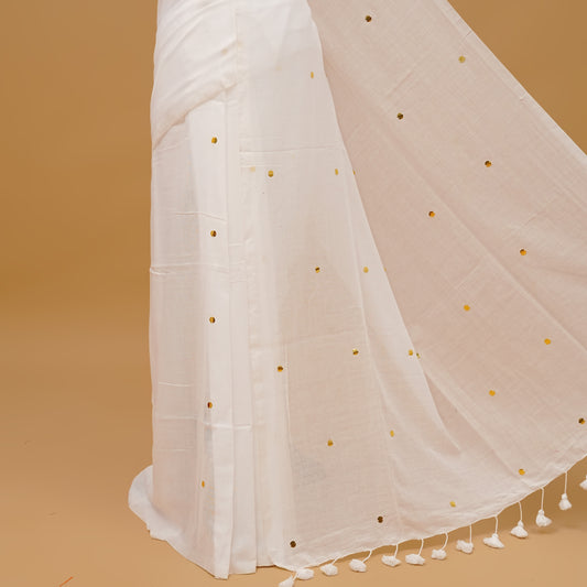 White colour mul cotton saree featuring sequin work on body & pallu finished with tassels. Paired with a matching blouse piece.