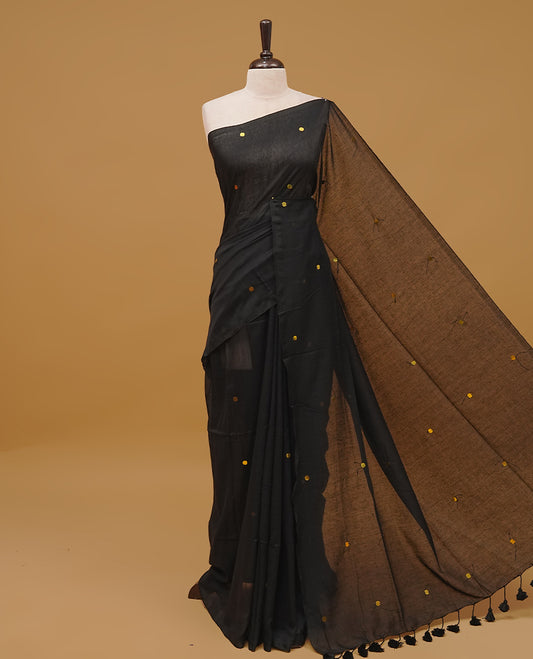 Black colour mul cotton saree featuring sequin work on body, without a border & pallu finished with tassels. Paired with a matching blouse piece.