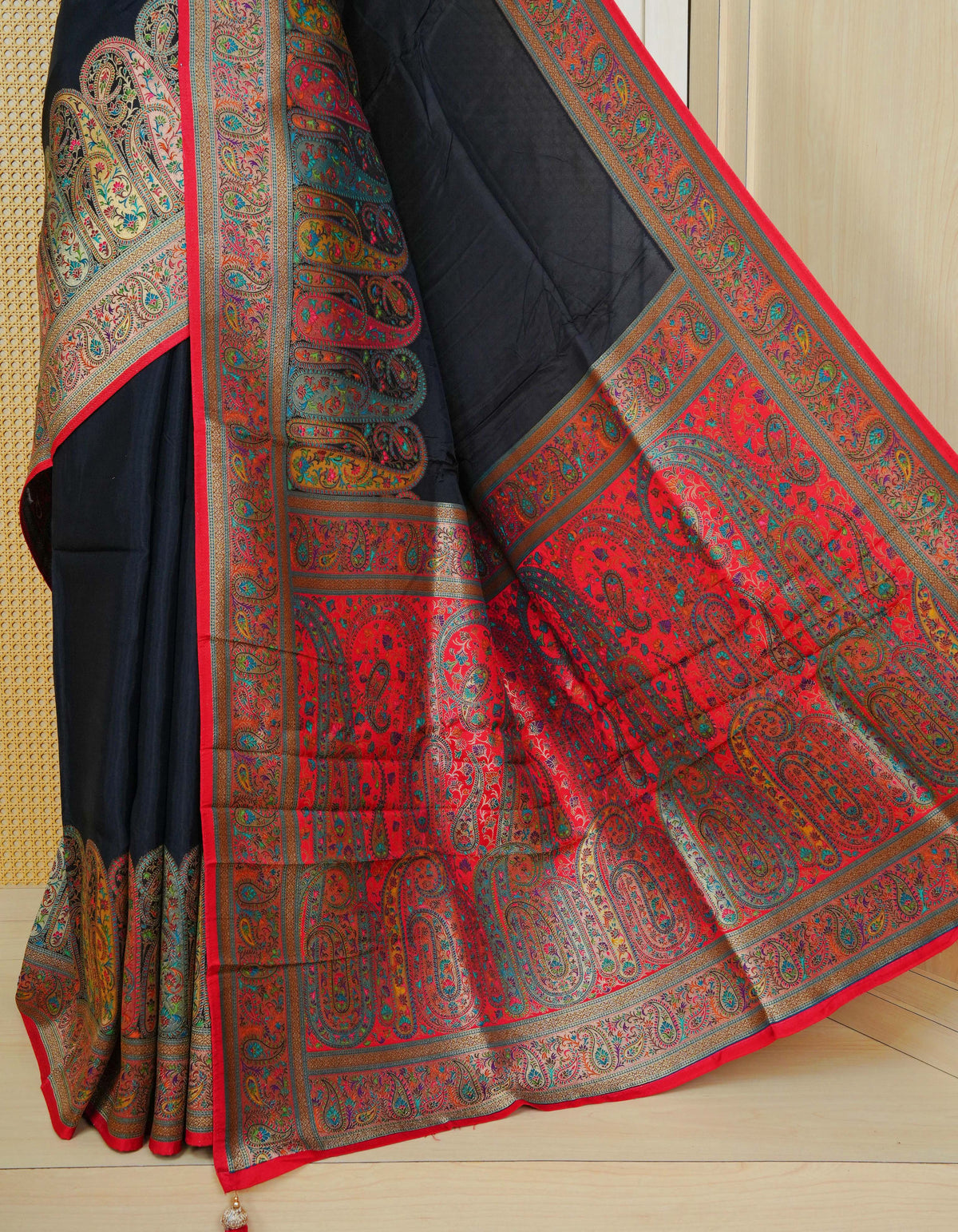 Black Colour Pashmina Saree featuring plain body, complemented by Contrast red colour with mango motifs zari patterns on border and Pallu, comes with matching blouse piece