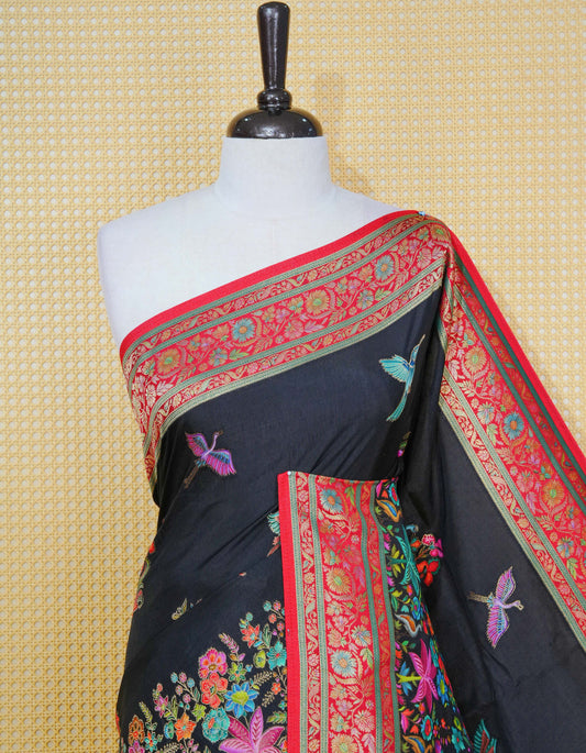 Black Colour Pashmina Saree featuring multi colour flower patterns on body, complemented by Contrast red colour floral motifs zari patterns on border and Pallu, comes with matching blouse piece