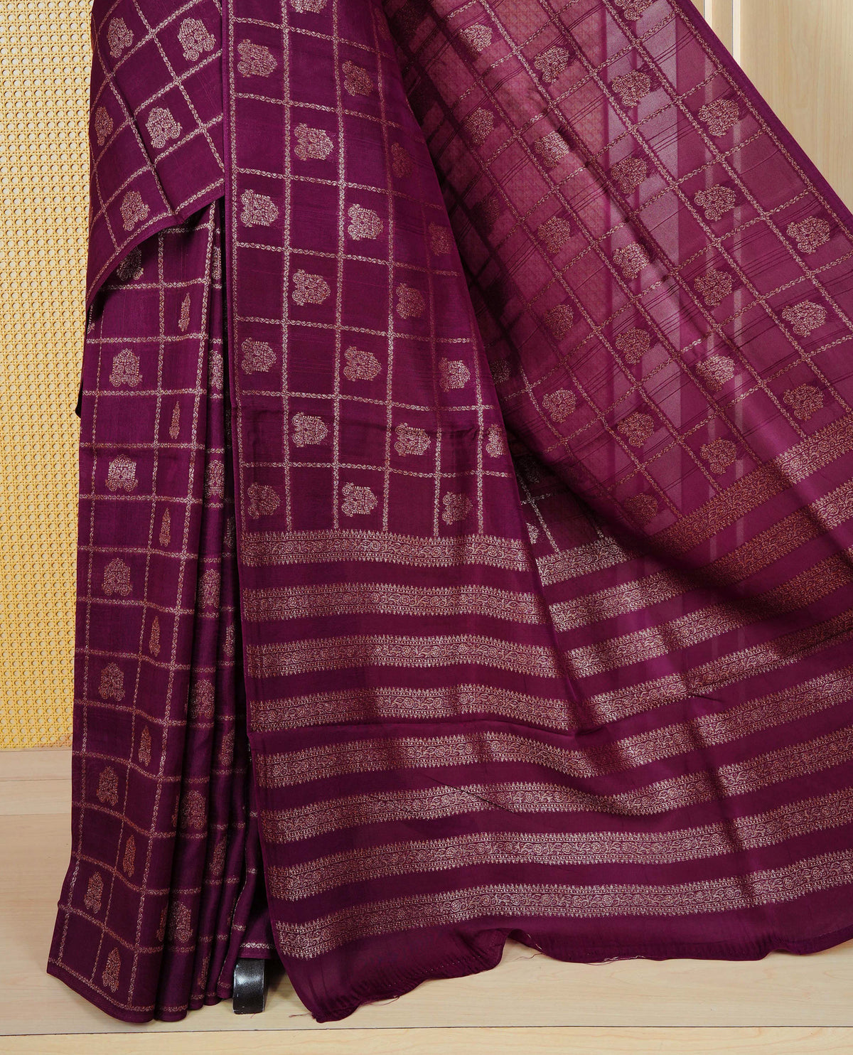 Wine colour semi banaras tussar georgette saree featuring gold zari check with motifs on body, no specific border and paired with matching blouse piece.