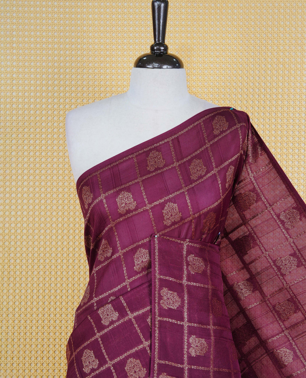 Wine colour semi banaras tussar georgette saree featuring gold zari check with motifs on body, no specific border and paired with matching blouse piece.