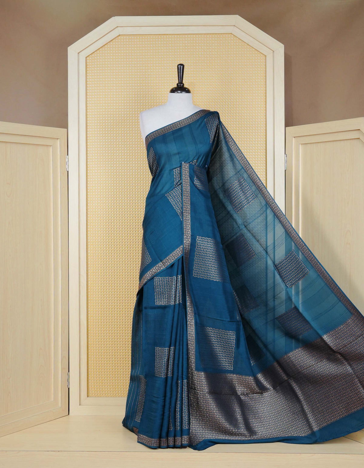 Dark blue colour semi banaras tussar georgette saree featuring gold zari geometric pattern on body, finished with gold zari geometric pattern border and paired with matching blouse piece.