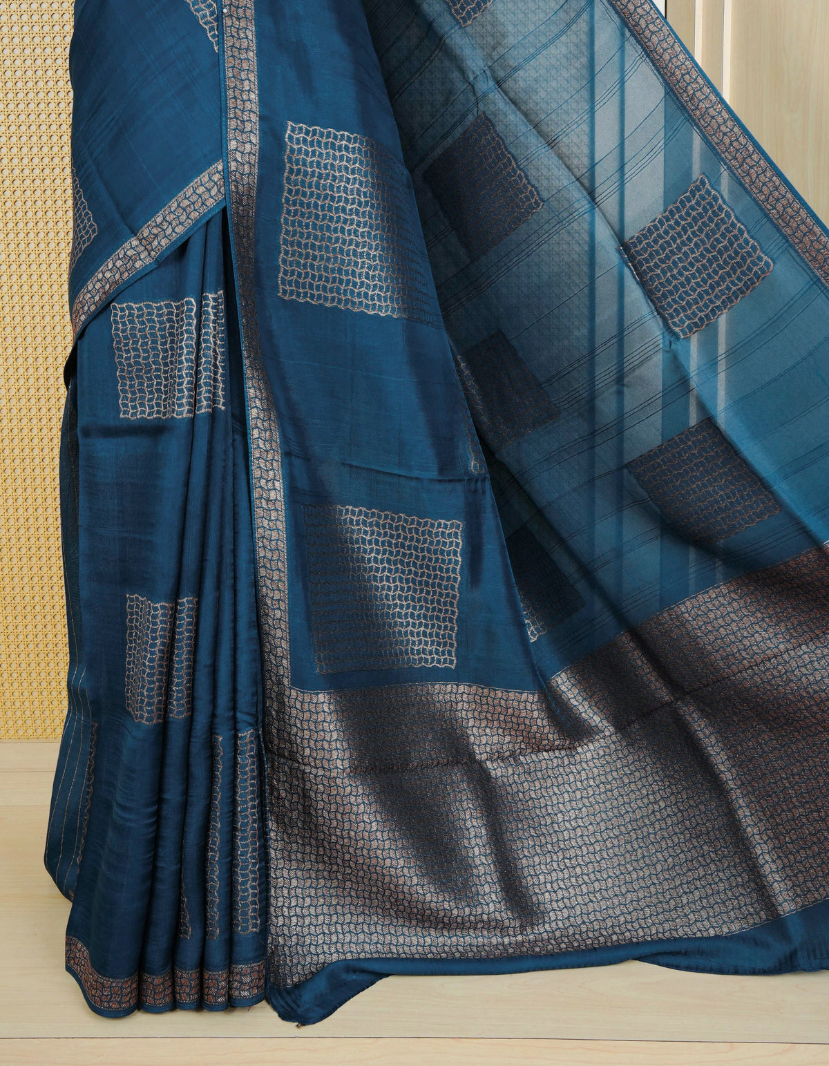 Teal colour semi banaras tussar georgette saree featuring gold zari geometric pattern on body, finished with gold zari geometric pattern border and paired with matching blouse piece.
