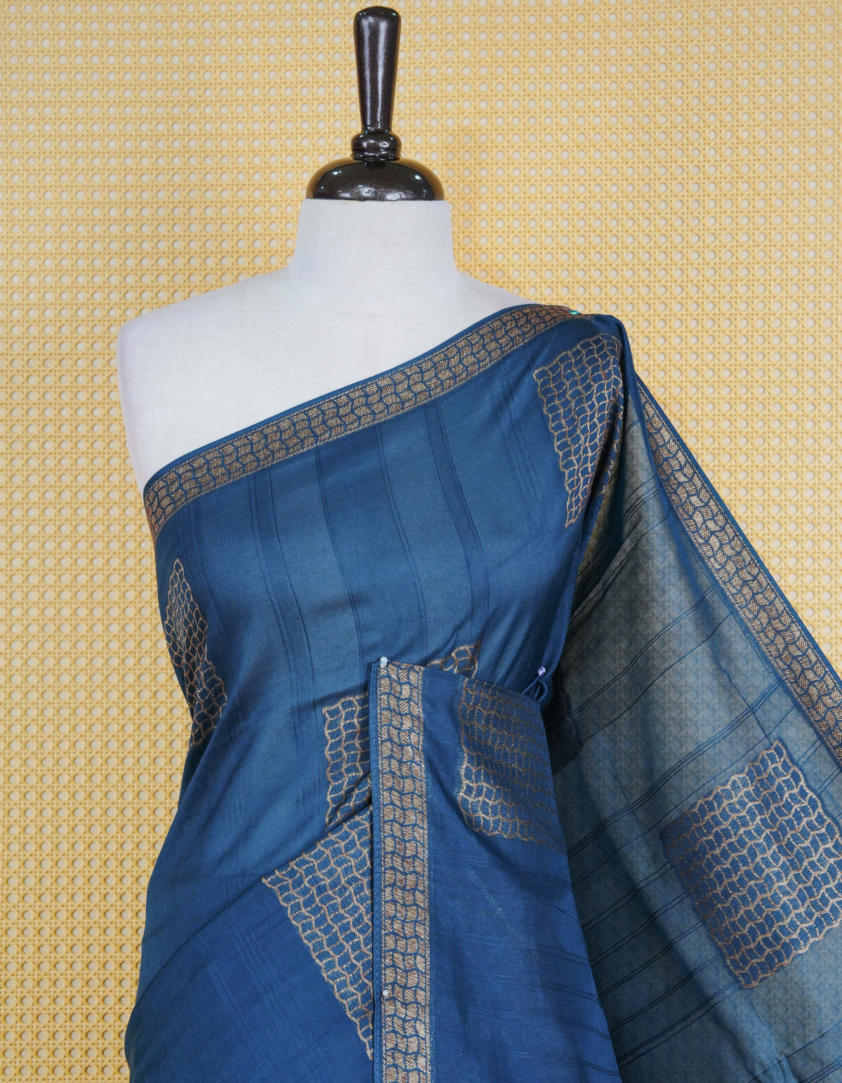 Dark blue colour semi banaras tussar georgette saree featuring gold zari geometric pattern on body, finished with gold zari geometric pattern border and paired with matching blouse piece.