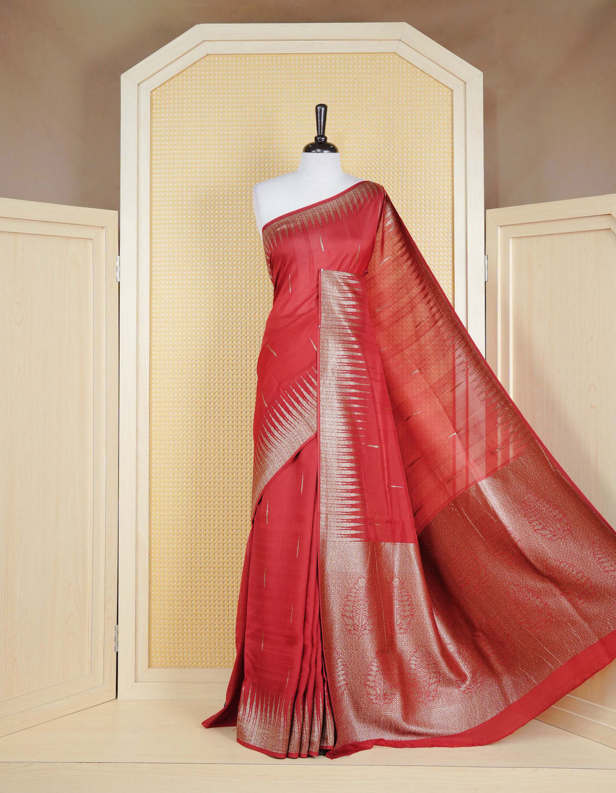 Brick red colour semi banaras tussar georgette saree featuring gold zari pattern on body, finished with gold zari temple border and paired with matching blouse piece.