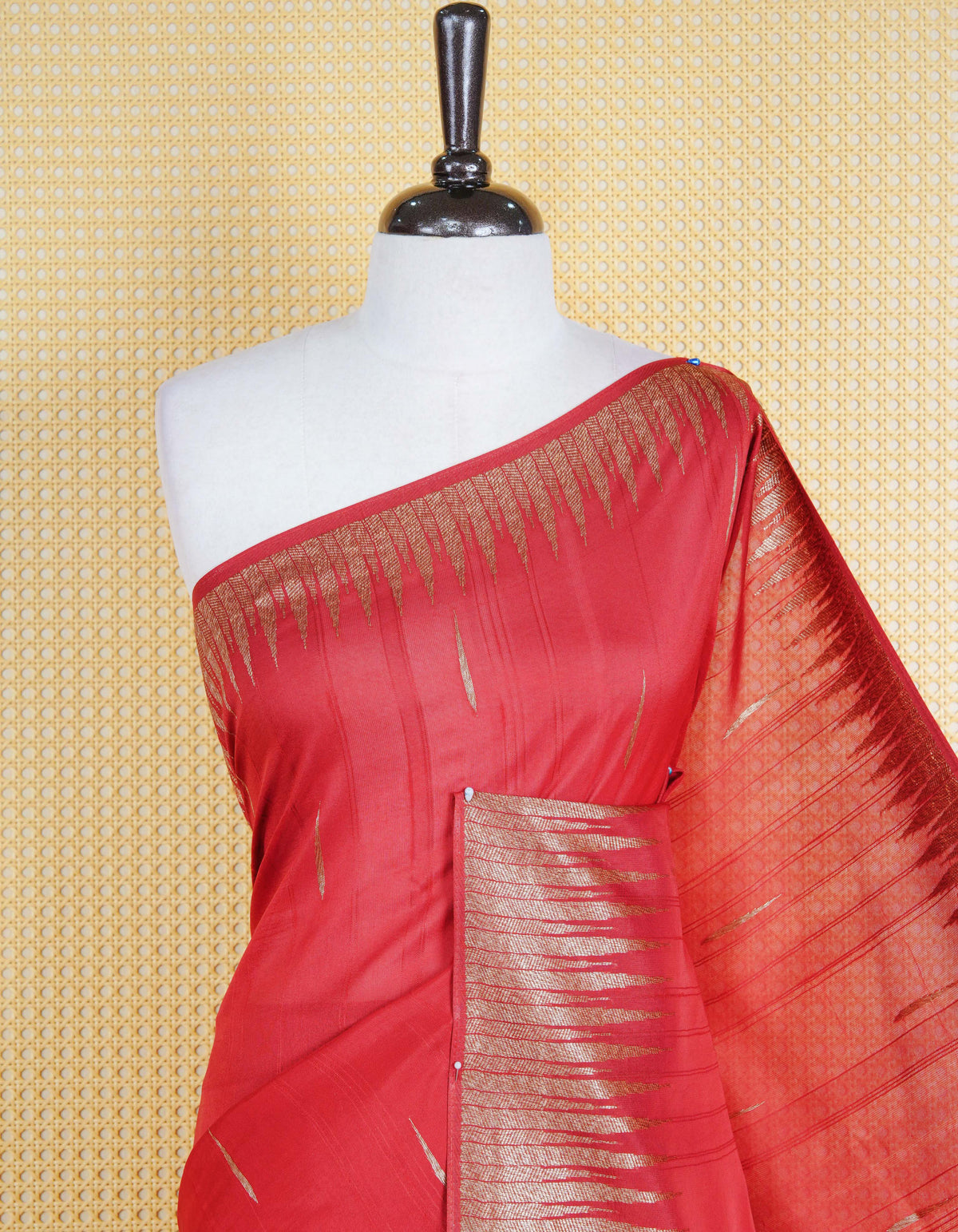 Brick red colour semi banaras tussar georgette saree featuring gold zari pattern on body, finished with gold zari temple border and paired with matching blouse piece.