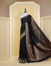 Black colour semi banaras tussar georgette saree featuring gold zari pattern on body, finished with gold zari temple border and paired with matching blouse piece.