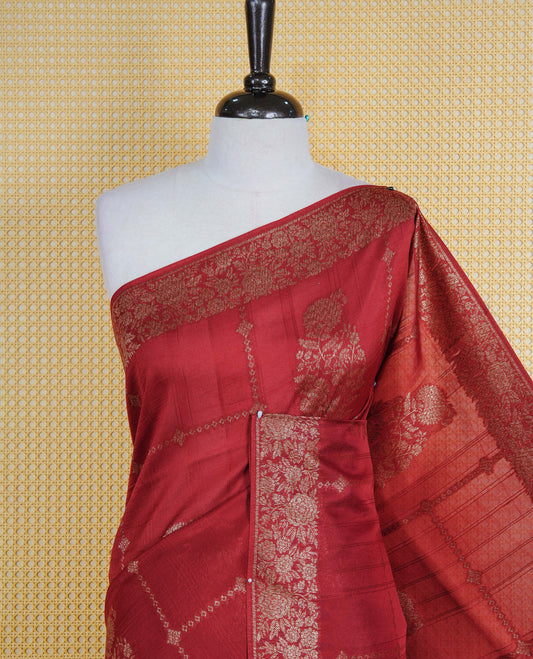 Brick red colour semi banaras tussar georgette saree featuring gold zari floral pattern on body, finished with gold zari floral motifs on border and paired with matching blouse piece.