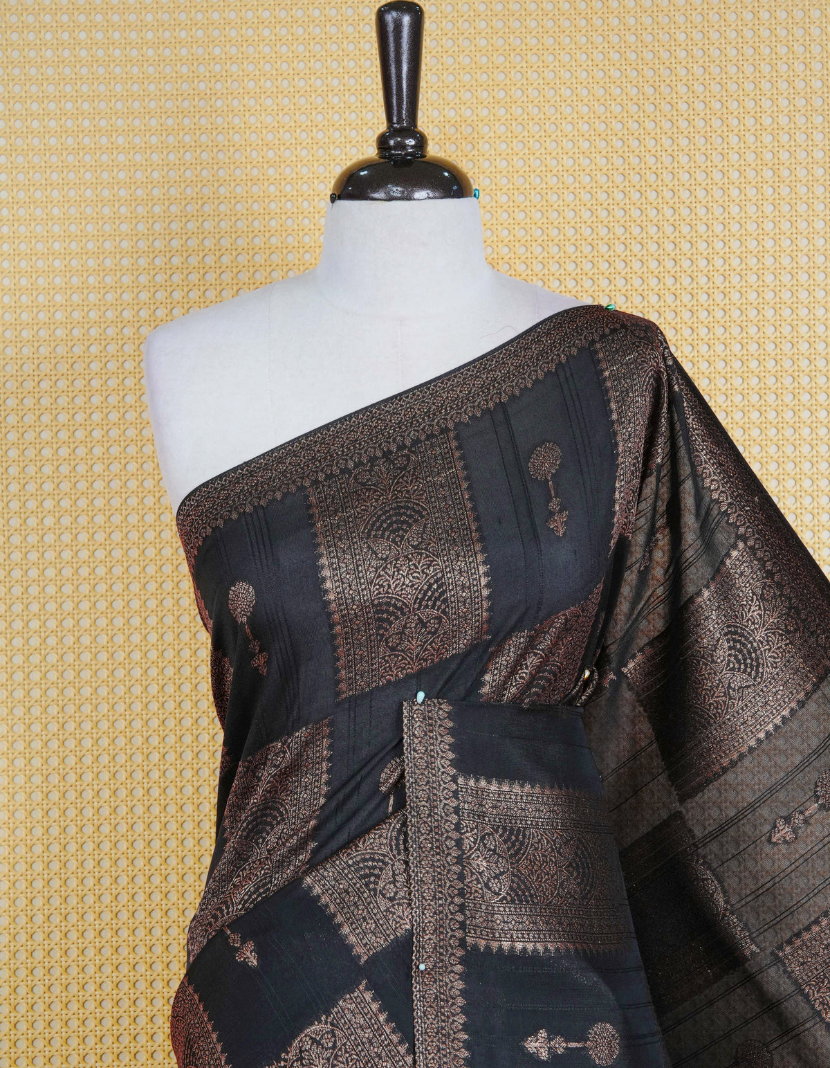 Black colour semi banaras tussar georgette saree featuring gold zari box pattern with motifs on body, finished with gold zari fancy border and paired with matching blouse piece.