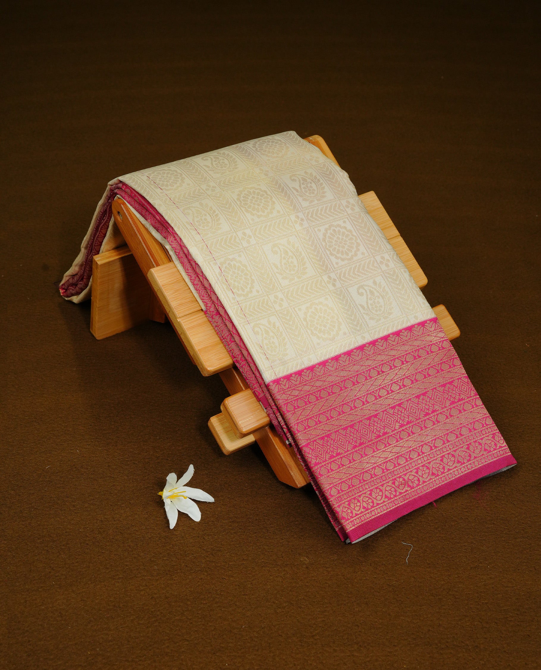 Cream Colour Semi Soft Silk Saree Featuring Gold zari Check With motifs Pattern On Body, Highlighted  by contrast Mauve border with Gold zari, paired with matching blouse piece.