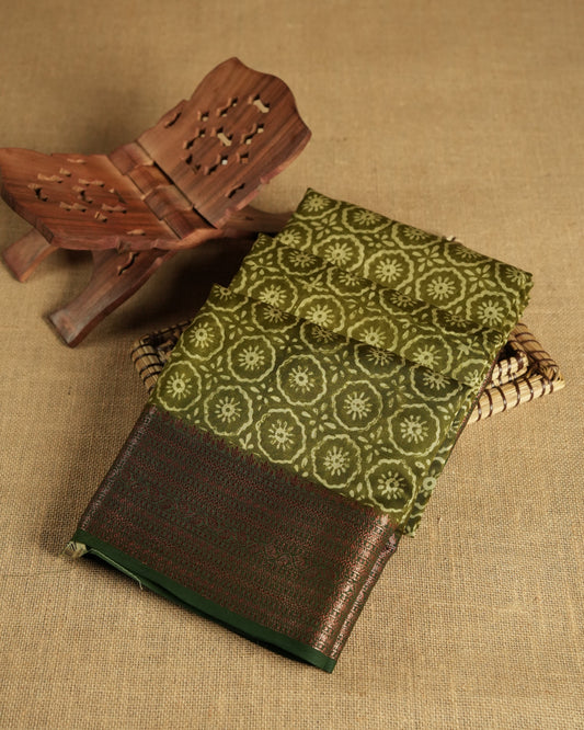 Olive colour chanderi silk saree with Floral block print On body, compilmented by  contrast dark green colour border with antique zari pattern and a matching blouse.