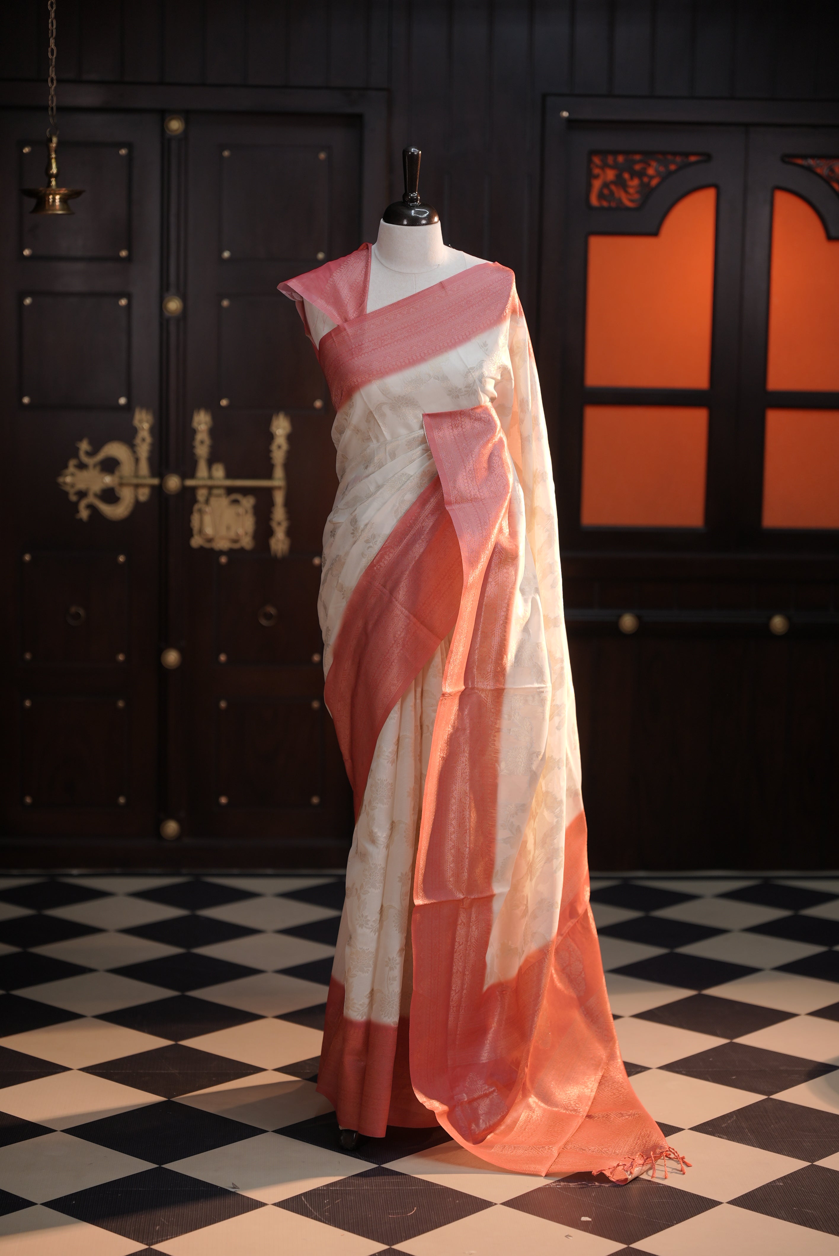 Cream colour Litchi silk saree highlighting antique floral thread pattern on body, contrast Pink colour border, pallu and comes with matching blouse piece.