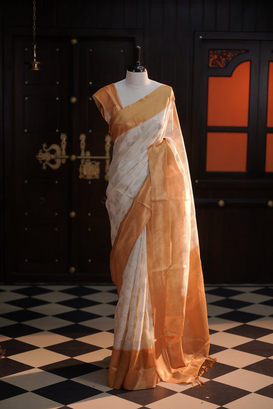 Cream colour Litchi silk saree highlighting antique floral thread pattern on body, contrast Yellow colour border, pallu and comes with matching blouse piece.