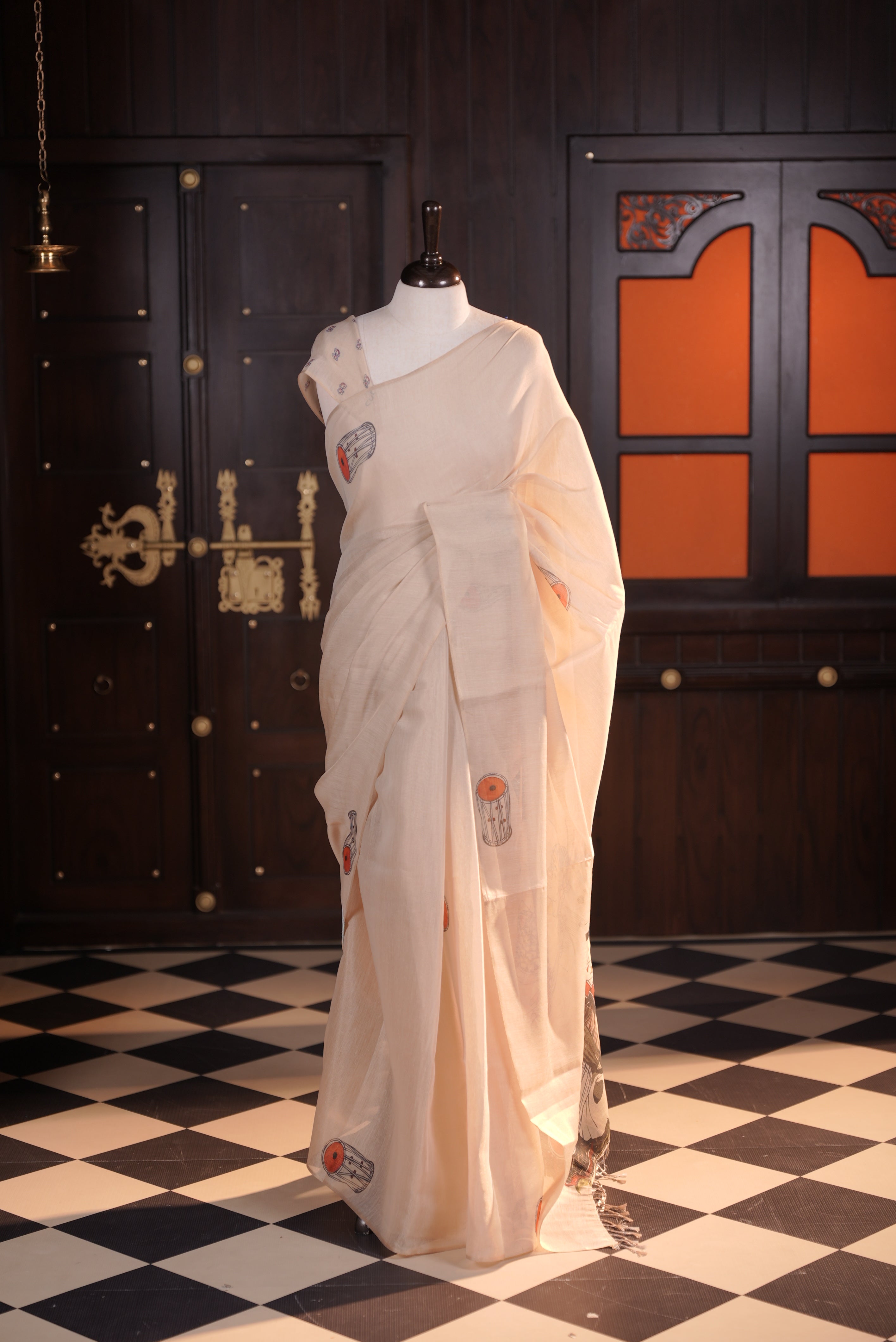 Beige colour semi linen tissue saree featuring instrument digital print throughout body, human printed pallu and small floral printed blouse piece.