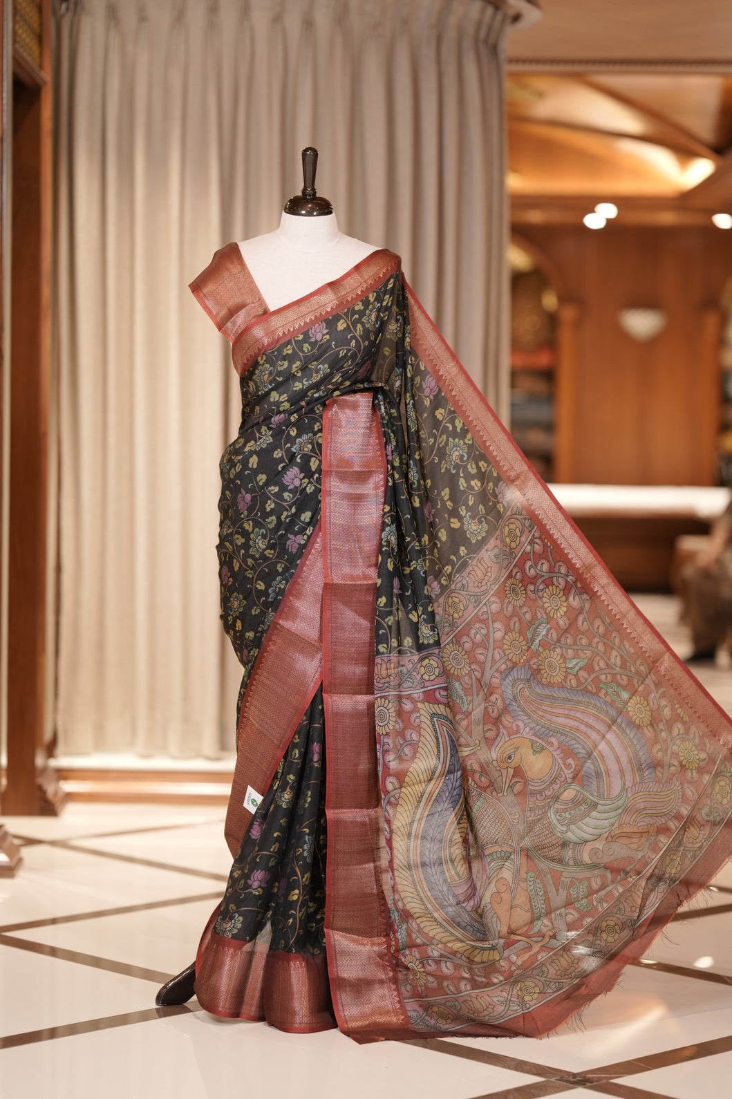 Black & Red colour Kalamkari saree in Milan moss fabric featuring intricate Kalamkari print, Adorned with a rich copper zari border and stunning contrast color design on the pallu and blouse piece for a graceful look.