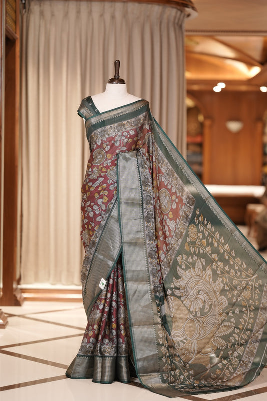 Maroon & Green colour Kalamkari saree in Milan moss fabric featuring intricate Kalamkari print, Adorned with a rich copper zari border and stunning contrast color design on the pallu and blouse piece for a graceful look.