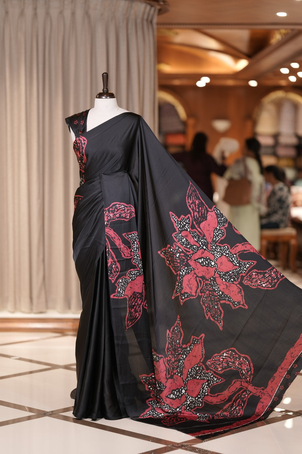 Black  colour modal satin saree featuring soft satin touch fabric with bold Red colour floral prints across the body and matching pallu & Comes with a coordinated floral printed blouse for a chic, graceful look