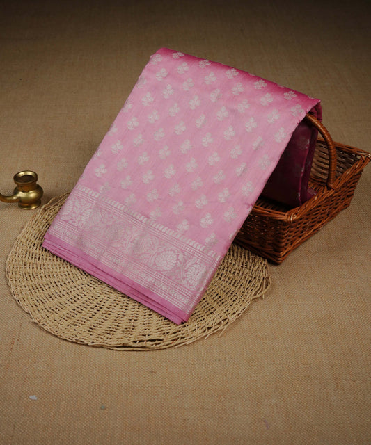 Pink colour Banarasi soft silk saree adorned with silver zari buttas, featuring intricate silver zari detailing and beautifully finished pallu with tassels. Paired with a matching blouse piece.