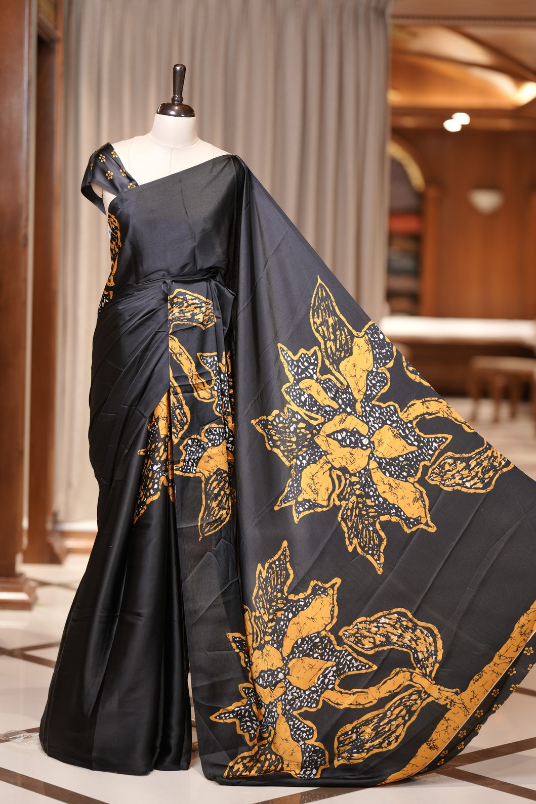 Black colour modal satin saree featuring soft satin touch fabric with bold Yellow colour floral prints across the body and matching pallu & Comes with a coordinated floral printed blouse for a chic, graceful look