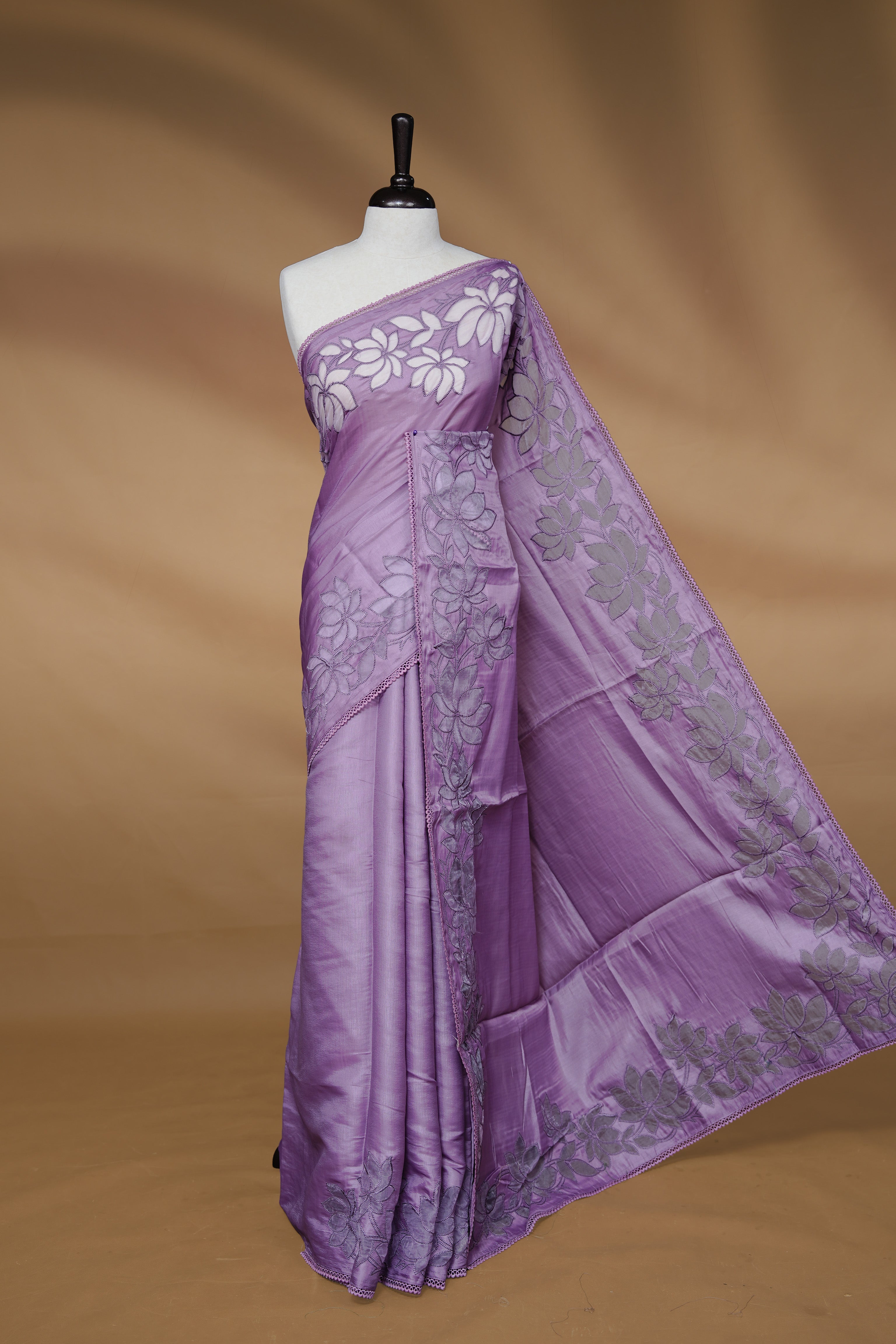 Pastel Purple colour Designer saree Featuring Elegant plain body, enhance with thread Lotus Pattern with lace border, paired with matching blouse piece.