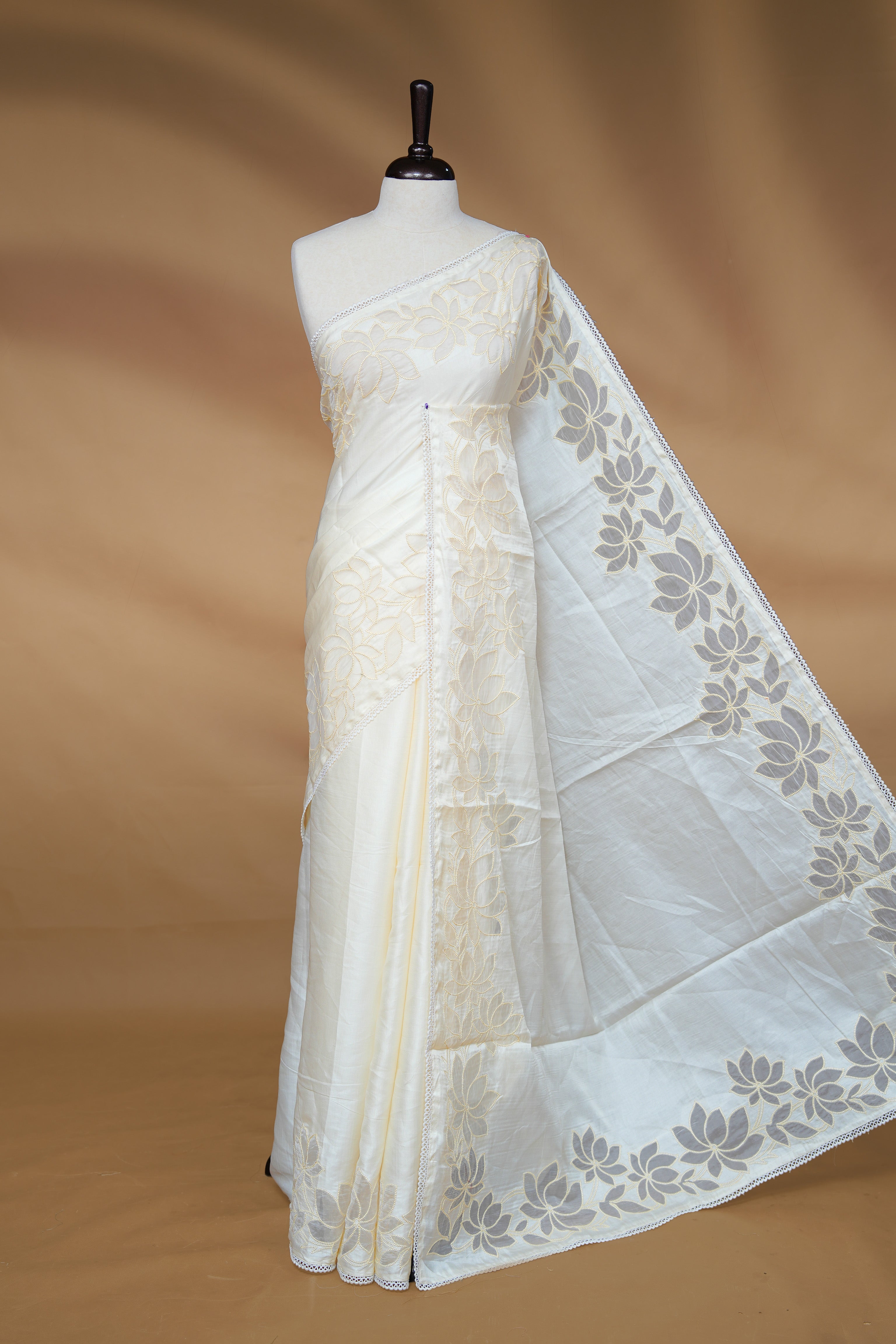 White colour Designer saree Featuring Elegant plain body, enhance with thread Lotus Pattern with lace border, paired with matching blouse piece.