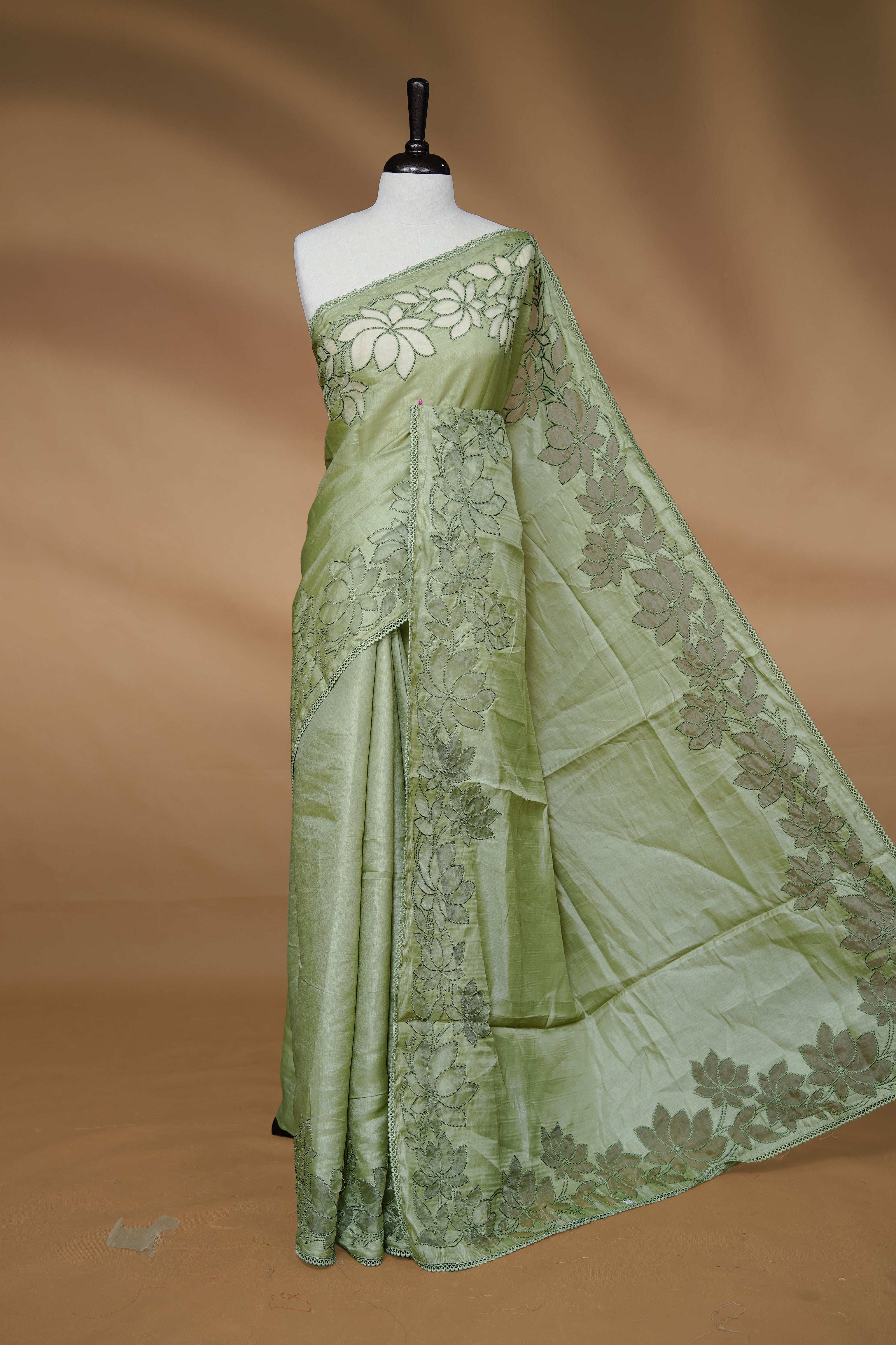 Pastel Green colour Designer saree Featuring Elegant plain body, enhance with thread Lotus Pattern with lace border, paired with matching blouse piece.