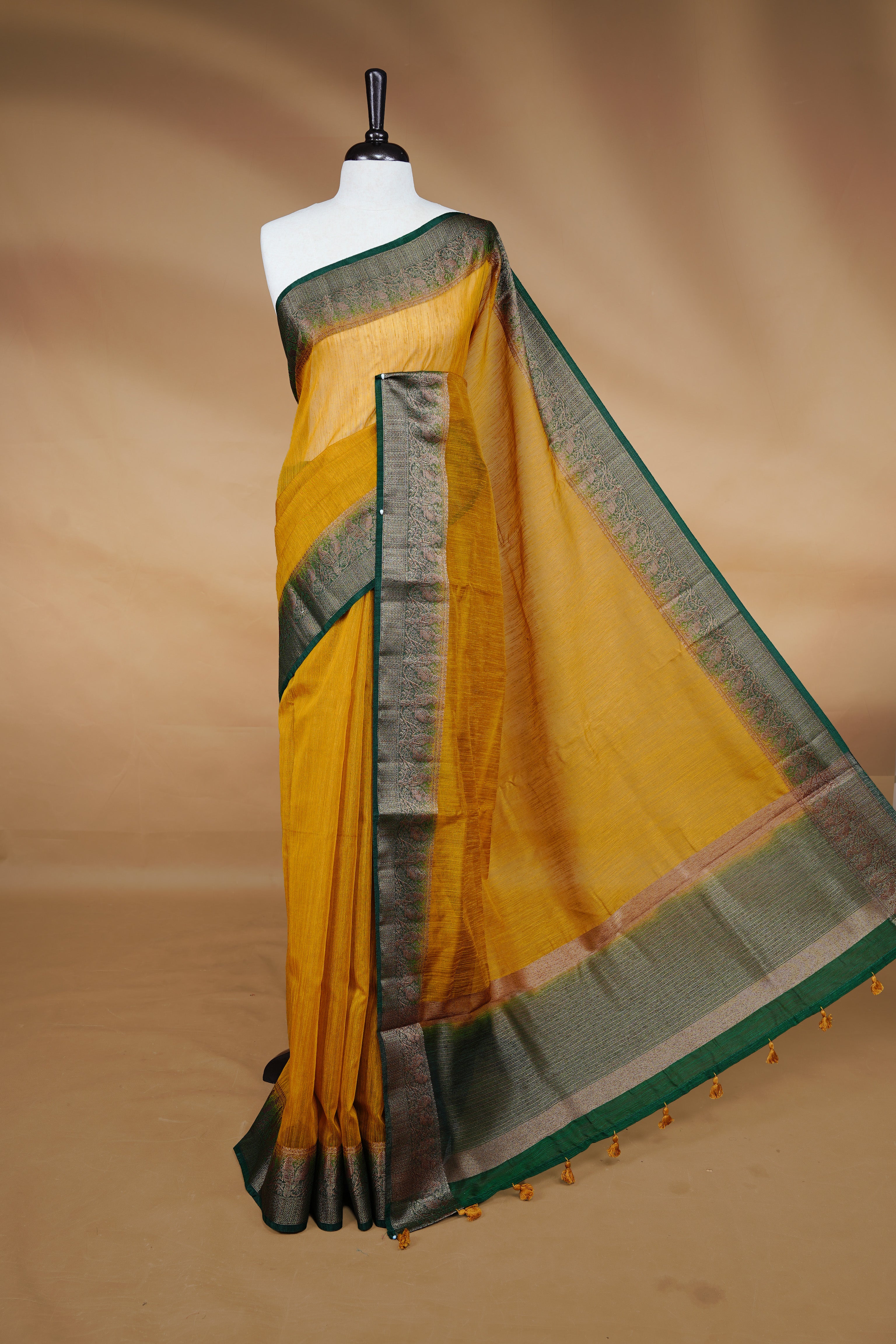 Yellow colour Semi linen saree featuring Elegant plain body, complemented by contrast Green colour With Antique zari border, paired with matching blouse piece.