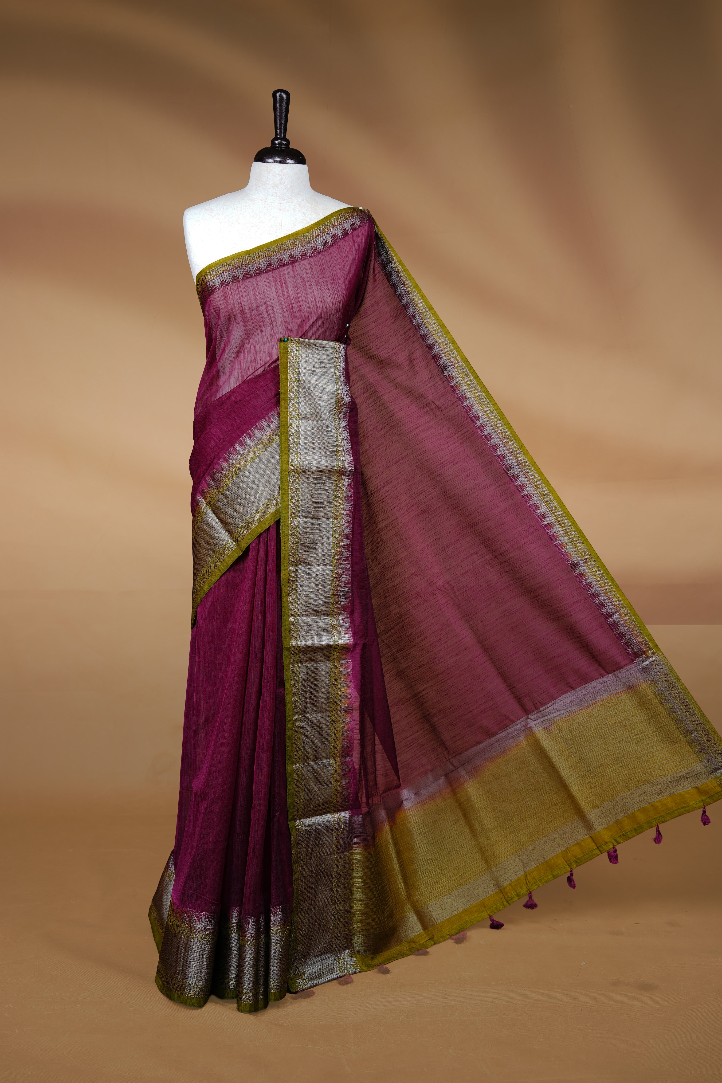 Grape colour Semi linen saree featuring Elegant plain body, complemented by contrast Green colour With Antique zari border, paired with matching blouse piece.
