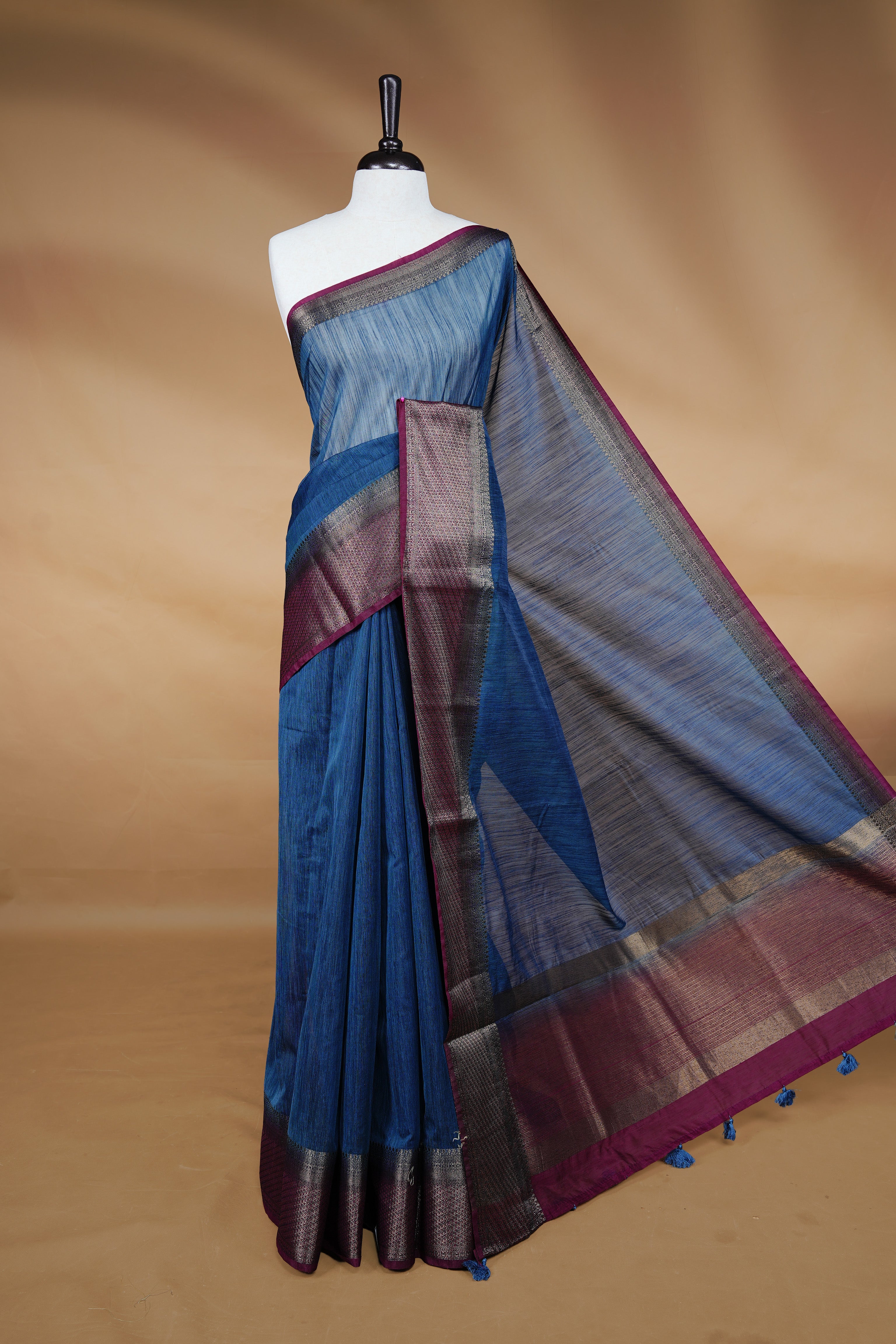 Teal colour Semi linen saree featuring Elegant plain body, complemented by contrast Maroon colour With Antique zari border, paired with matching blouse piece.