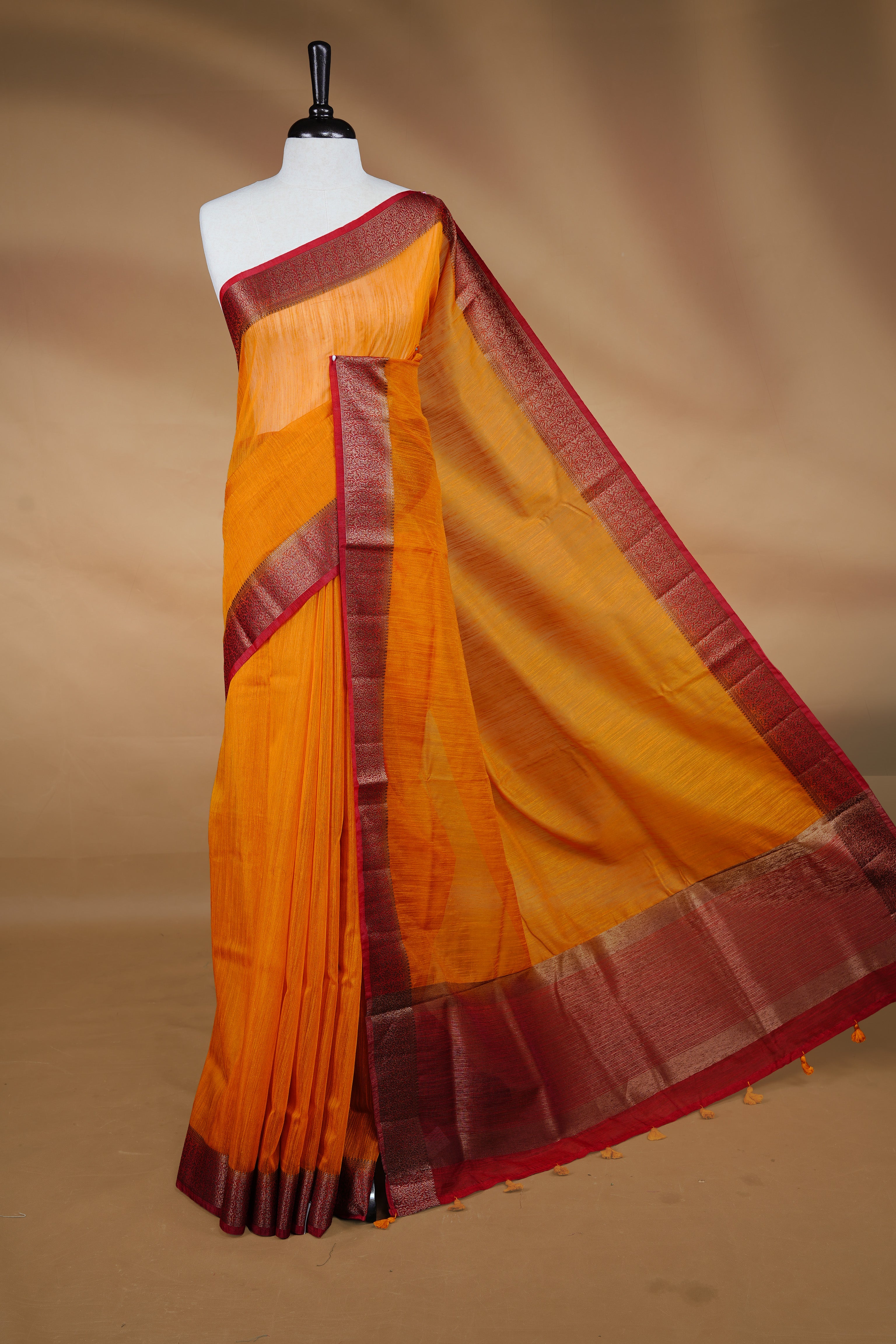 Mustard colour Semi linen saree featuring Elegant plain body, complemented by contrast Maroon colour With Antique zari border, paired with matching blouse piece.