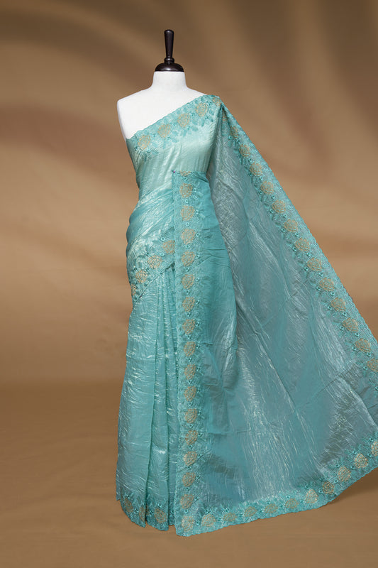 Aqua colour Crush Organza Featuring Plain body, Enrich with Floral thread pattern & scalp border, paired with matching blouse piece.