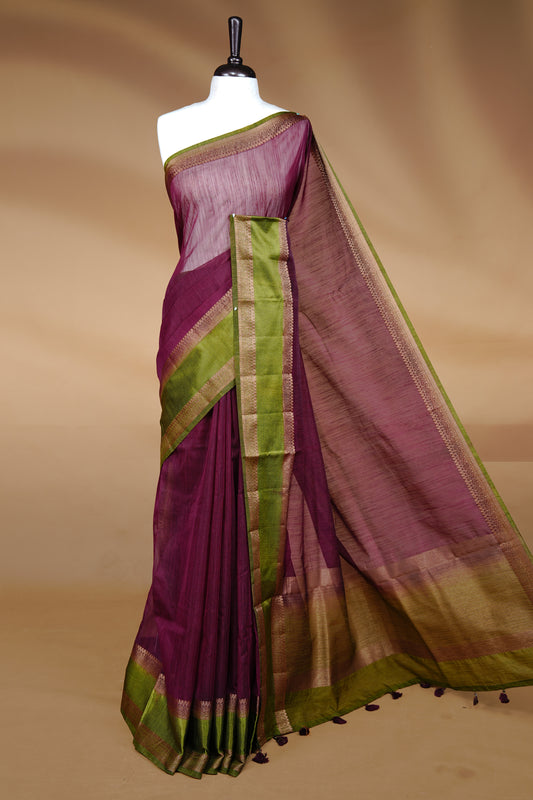 Maroon colour Semi linen saree featuring Elegant plain body, complemented by contrast Green colour With Antique zari border, paired with matching blouse piece.