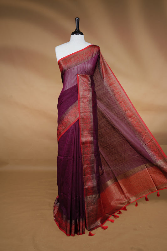 Maroon colour Semi linen saree featuring Elegant plain body, complemented by contrast Red colour With Antique zari border, paired with matching blouse piece.