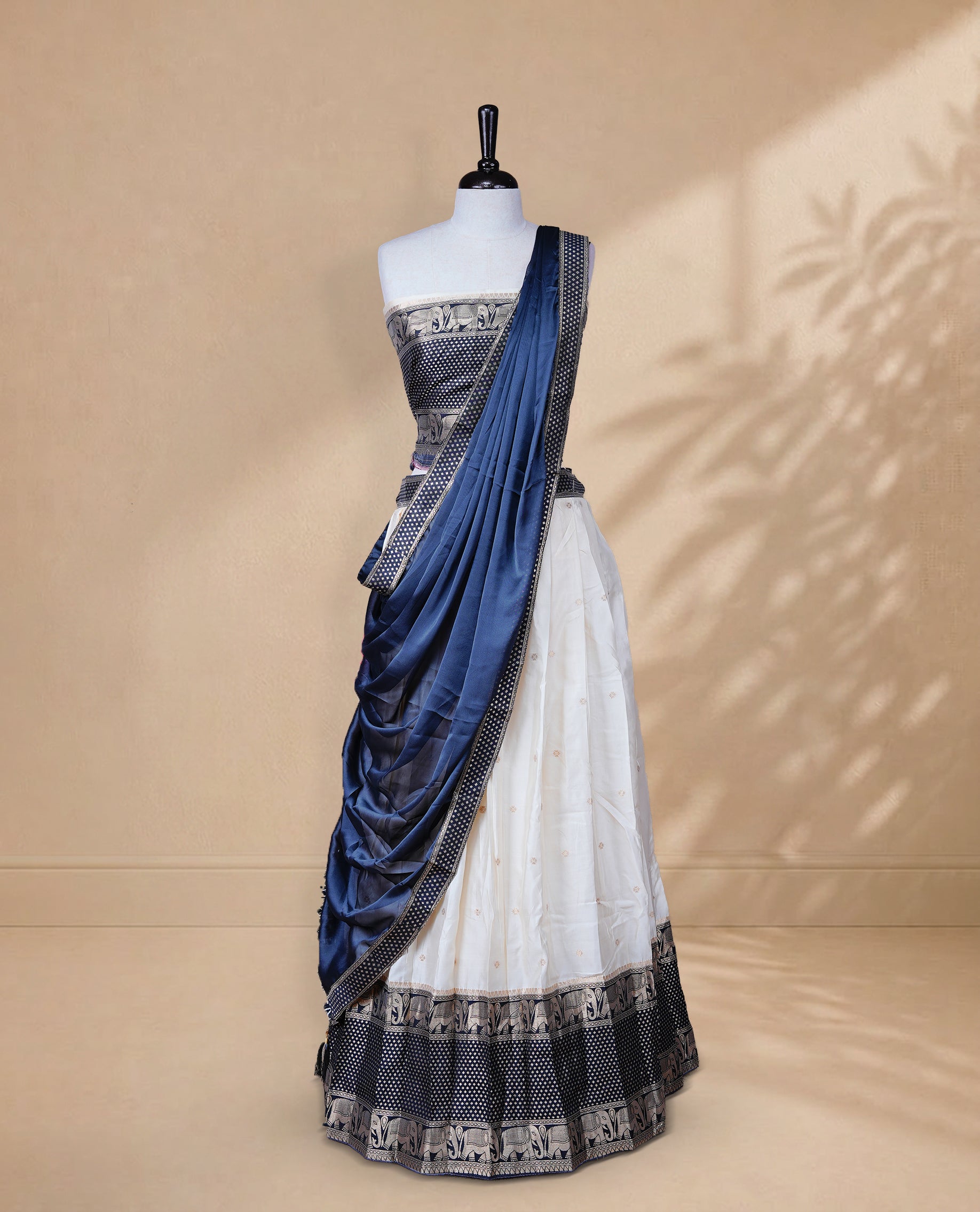Cream colour Half saree featuring Gold zari buttas on skirt with Zari border on contrast Black colour border, Unstitched Blouse and matching dupatta.