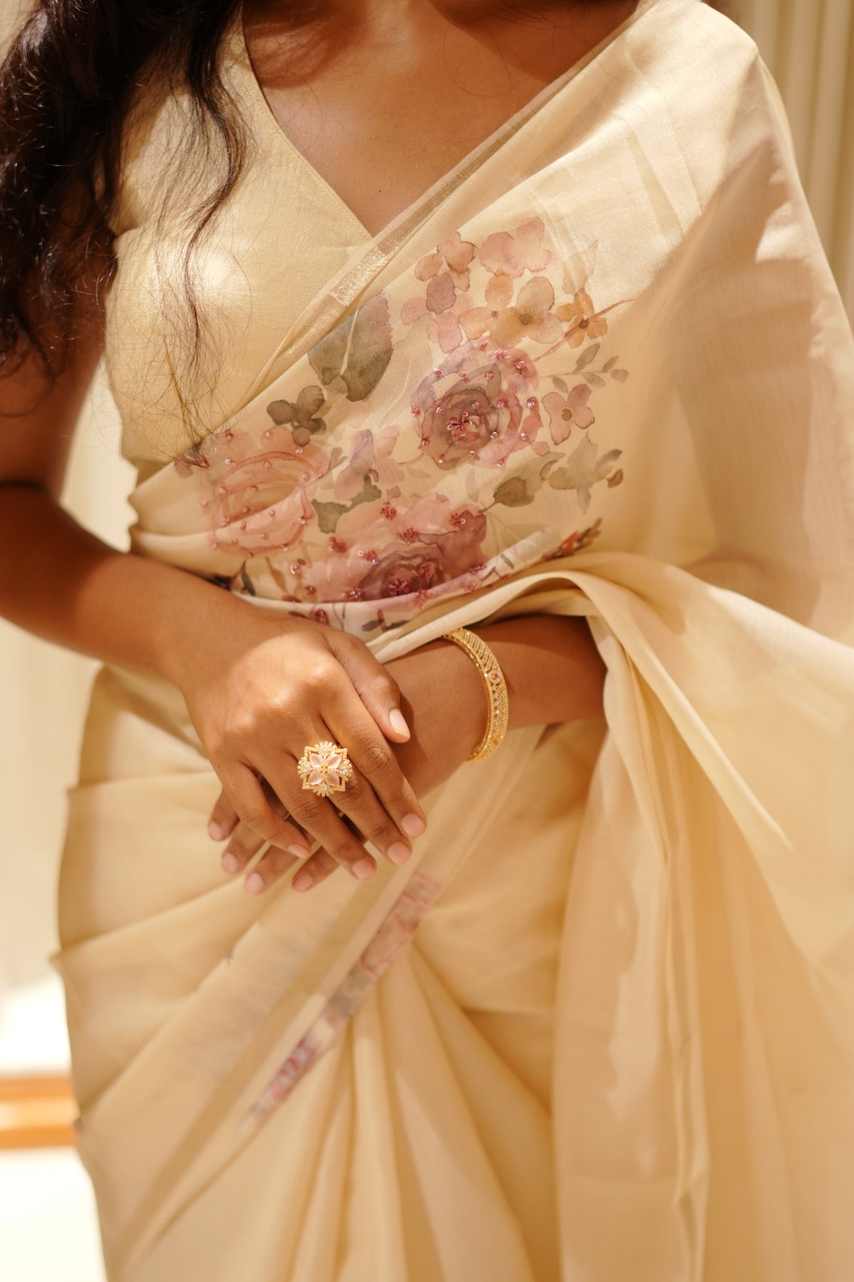 Cream colour Chanderi silk saree featuring floral digital print with sequins With thread buttas on print, complemented by simple gold kasavu kara & elegant tassels on pallu.