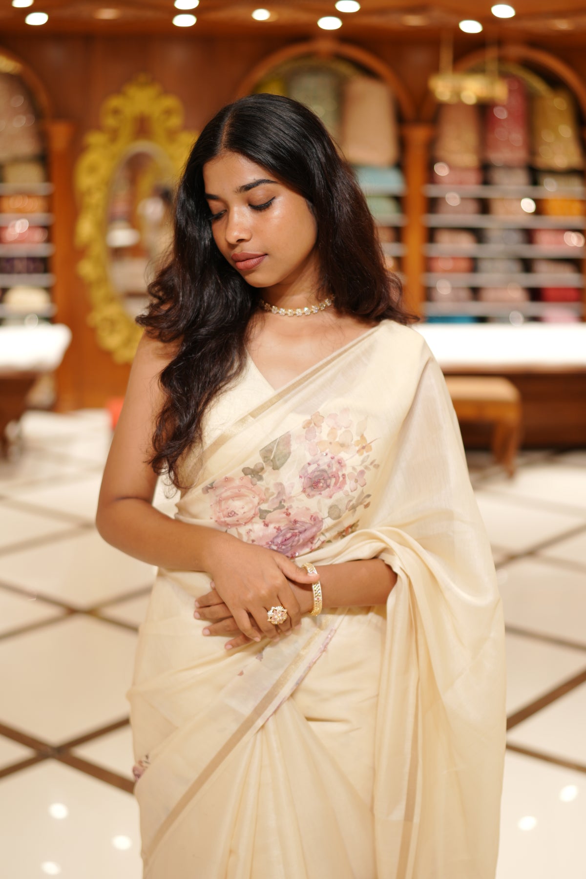 Cream colour Chanderi silk saree featuring floral digital print with sequins With thread buttas on print, complemented by simple gold kasavu kara & elegant tassels on pallu.